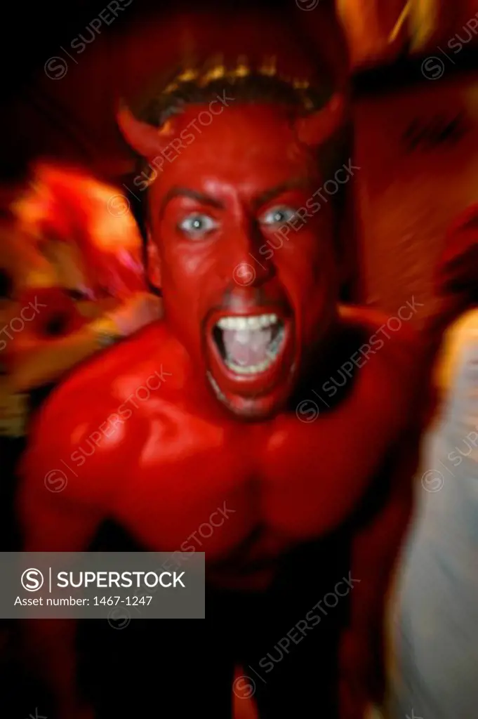 Portrait of a young man wearing devil horns