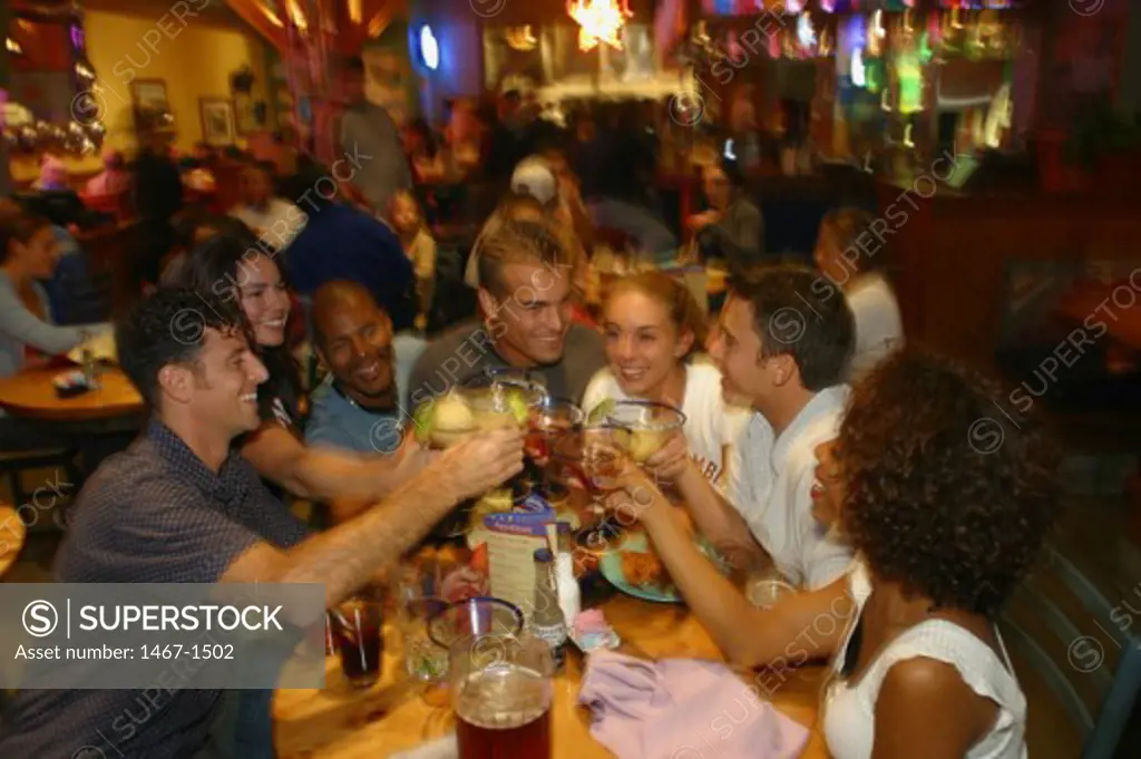 High angle view of a group of a people toasting with martinis in a bar