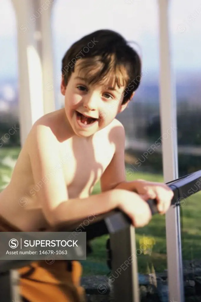 Portrait of a boy leaning against a railing