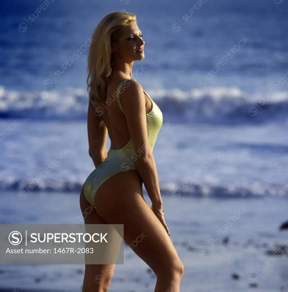 Side profile of a young woman standing on the beach