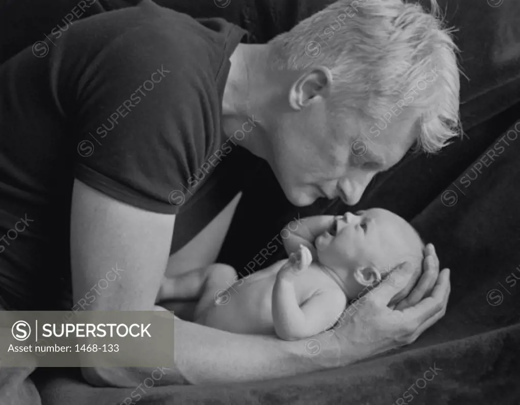 Side profile of a man holding a baby