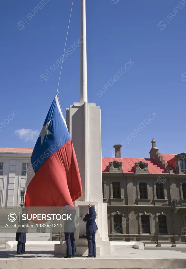 Three army soldiers raising the Chilean Flag, Punta Arenas, Patagonia, Chile
