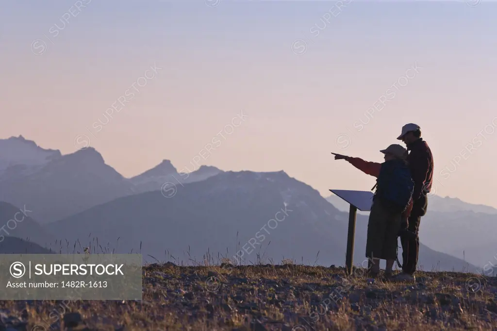 Couple in mountains, woman pointing to distance, Slate Peak, Pasayten Wilderness, Okanogan National Forest, Washington State, USA