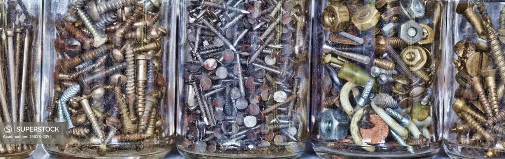 Close-up of nuts and bolts with screws and nails in jars