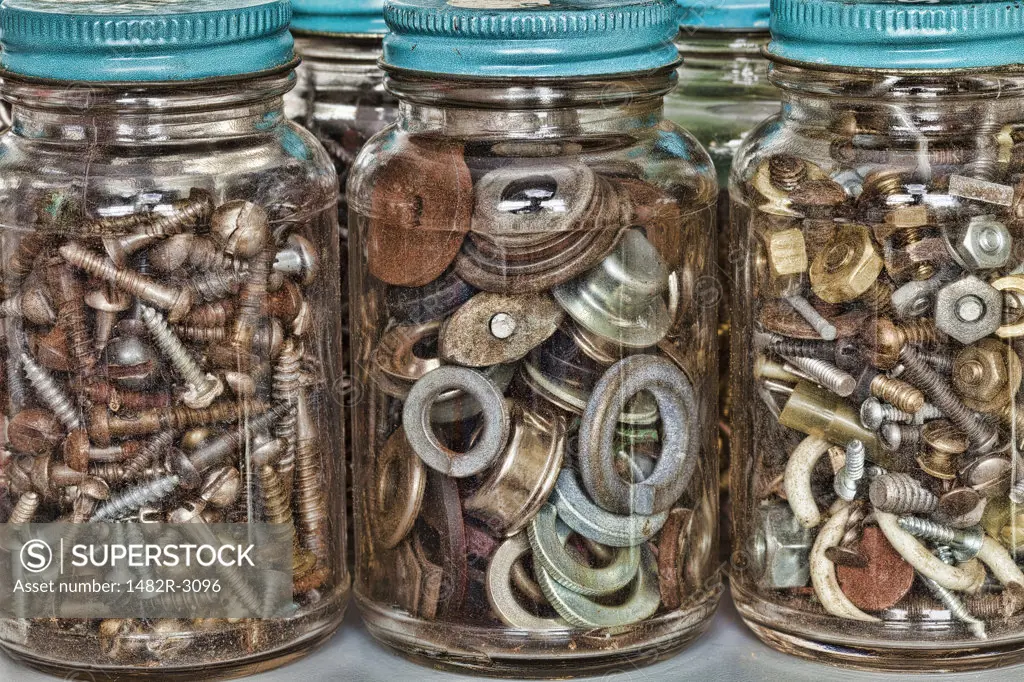 Close-up of nuts and bolts with screws and washers in jars