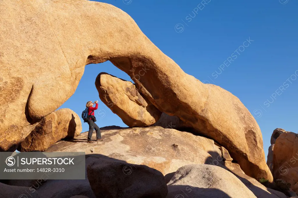 USA, California, Joshua Tree National Park, Woman under Arch Rock