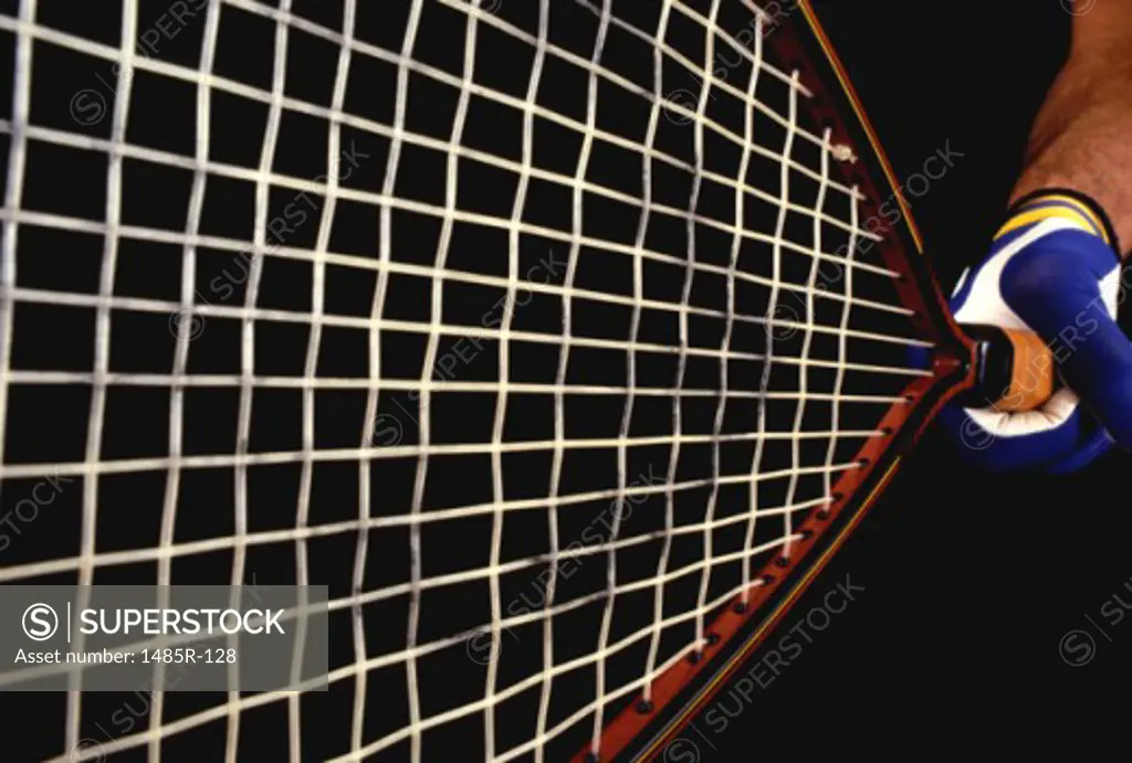 Close-up of a person holding a tennis racket