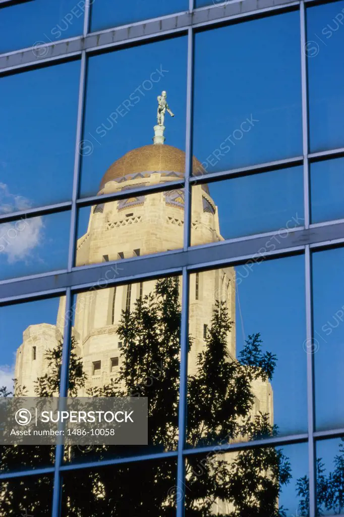 Reflection of a government building on the glass of a building, State Capitol, Lincoln, Nebraska, USA