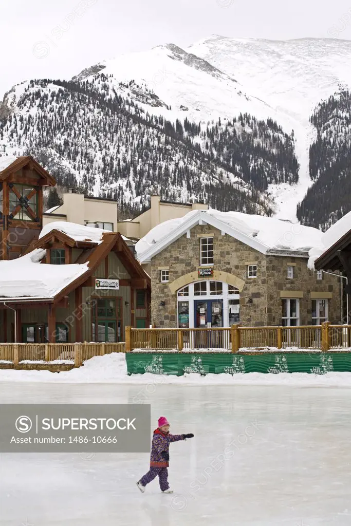 Person ice skating in front of ski resort, Copper Mountain Ski Resort, Colorado, USA