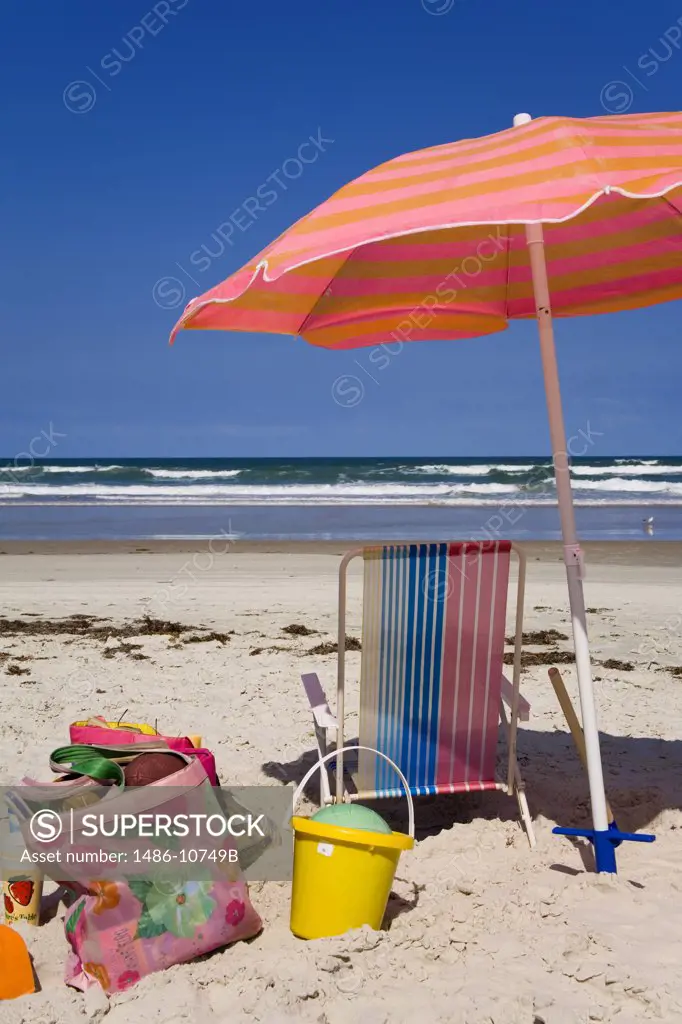 Umbrella and a beach chair on the beach, Daytona Beach, Florida, USA