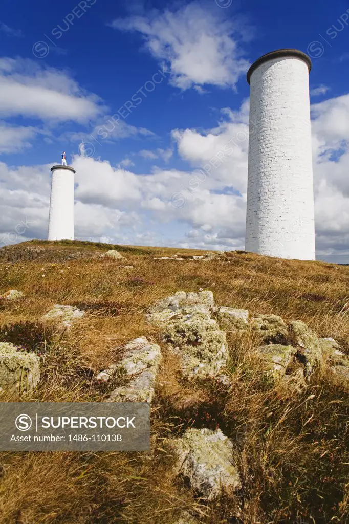 Low angle view of two beacon towers on a landscape, Metal Man, Tramore, County Waterford, Munster Province, Ireland