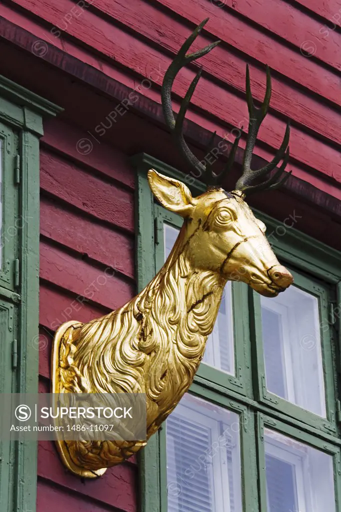 Golden sculpture of a deer on a building, Historic Bryggen District, Bergen, Norway