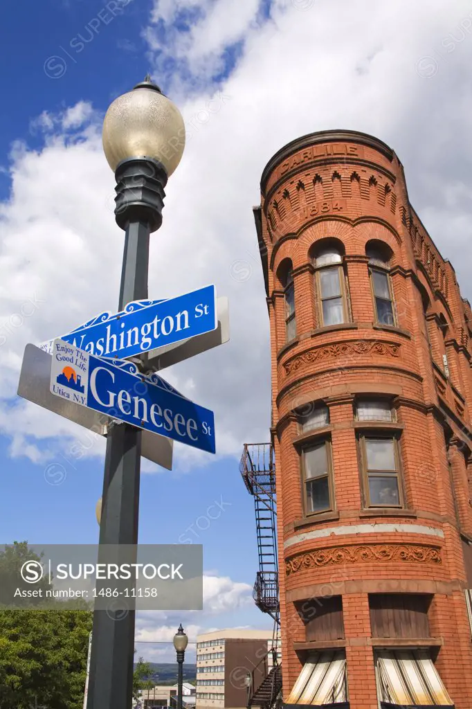 Low angle view of street name signs in front of a building, Carlile Building, Utica, New York State, USA