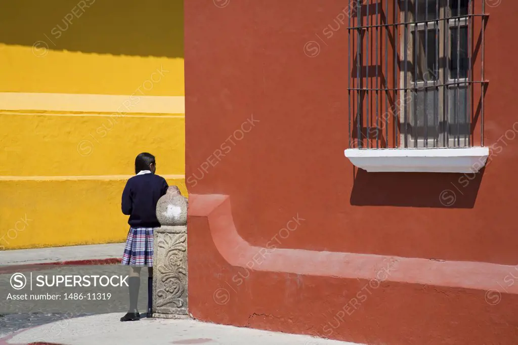 Girl standing outside a school building, Antigua Guatemala, Guatemala