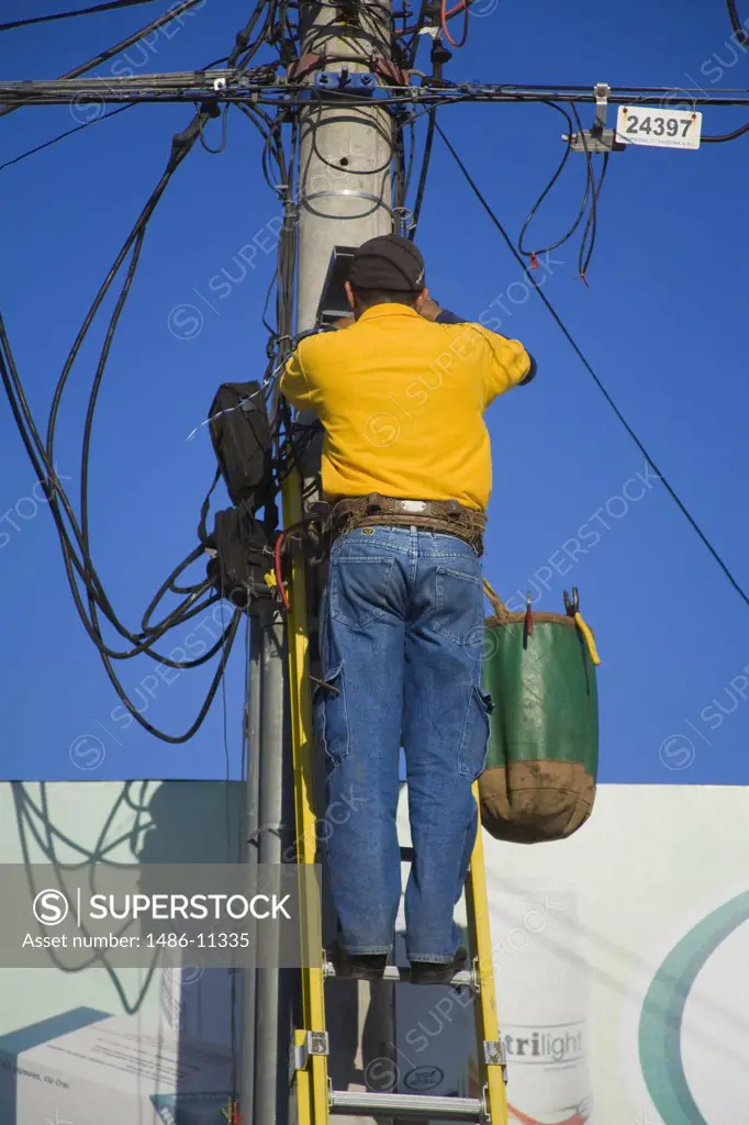 Low angle view of a technician repairing a telephone line, Puntarenas, Puntarenas Province, Costa Rica