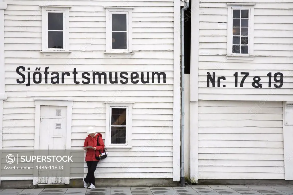 Woman leaning against the wall of a museum, Maritime Museum, Stavanger, Rogaland County, Norway