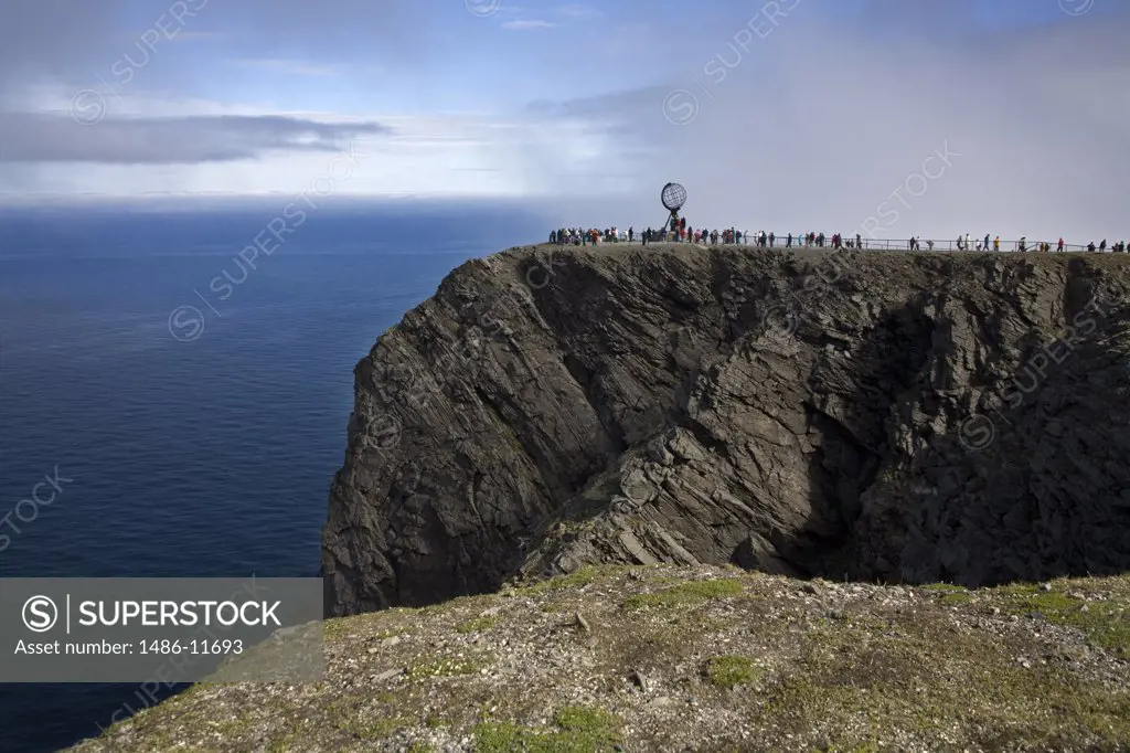 Tourists and a sculpture on a cliff, Honningsvag Port, Honningsvag, Mageroya Island, Nordkapp, Finnmark County, Norway