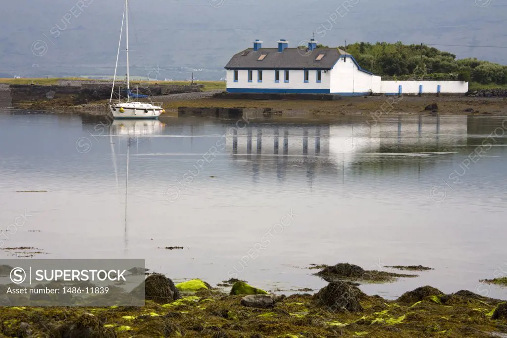 Reflection of a building in water, Finavarra Peninsula, The Burren, County Clare, Munster Province, Republic of Ireland