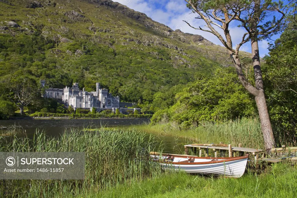 Boat at the lakeside with an abbey in the background, Kylemore Abbey, Lake Kylemore, Connemara, County Galway, Connacht Province, Republic of Ireland