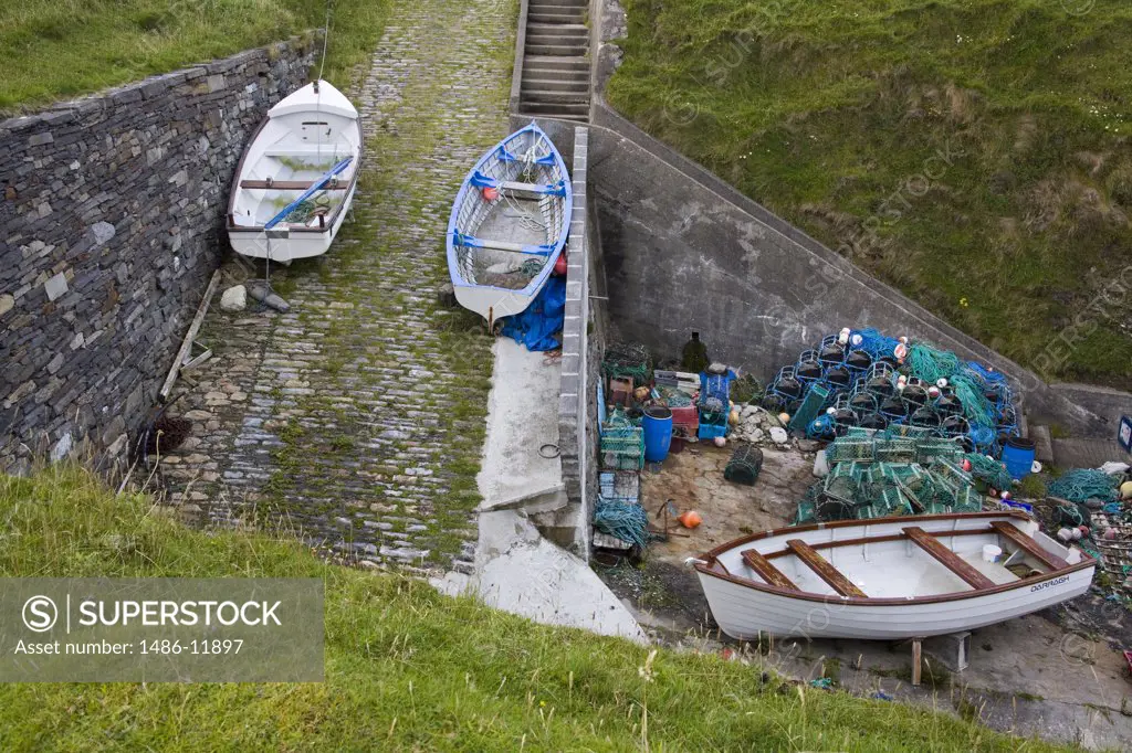 Garbage cans with fishing boats on a pier, Malin Beg, County Donegal, Ulster Province, Ireland