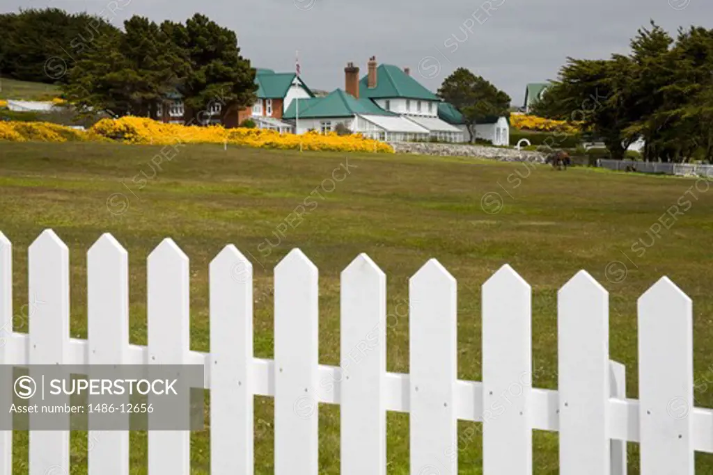 Picket fence with government building in the background, Port Stanley, Stanley, Falkland Islands