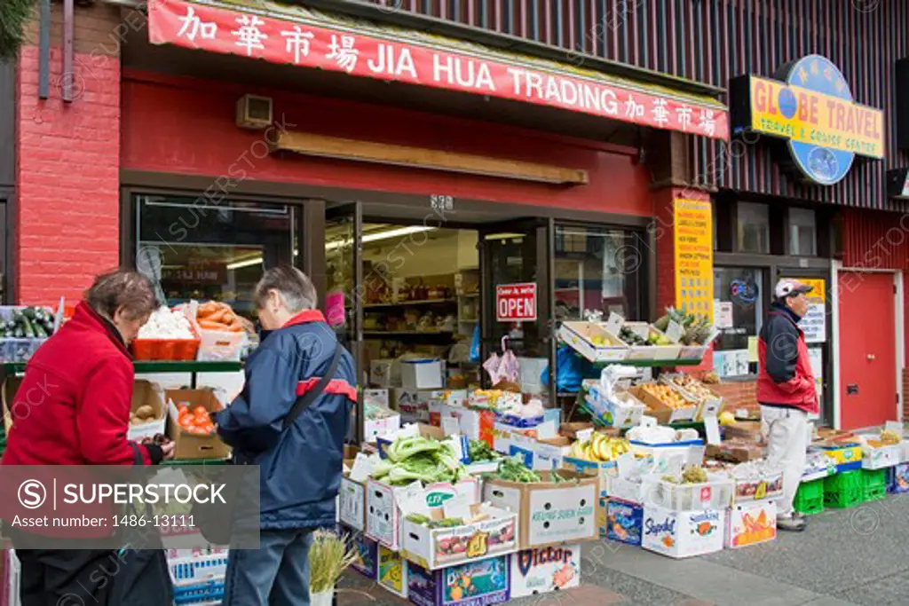 Canada, British Columbia, Vancouver Island, Victoria, Senior couple outside shop in Chinatown