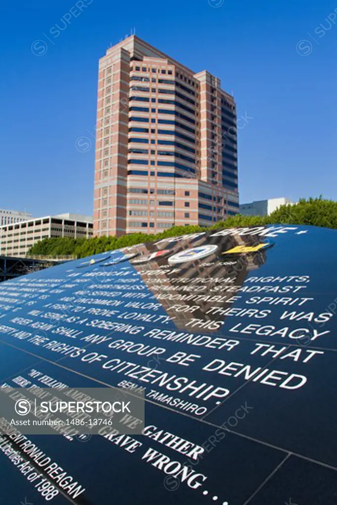 Reflection of a building on a memorial plaque, Go For Broke National Monument & Federal Building, Little Tokyo, Los Angeles, California, USA