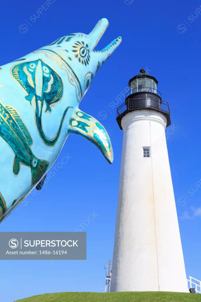 Sculpture of dolphin in front of a lighthouse, Point Isabel Lighthouse, Port Isabel, Texas, USA