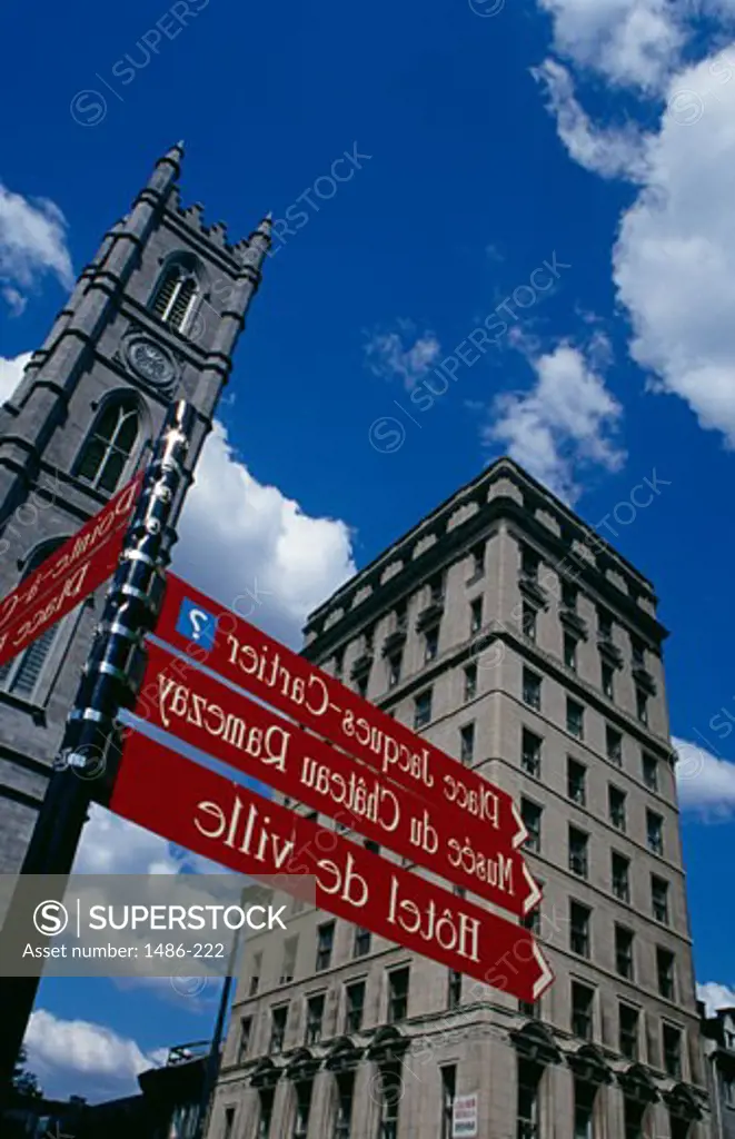 Street name sign with a church and a skyscraper, Notre Dame de Montreal, Place D'Armes, Montreal, Quebec, Canada