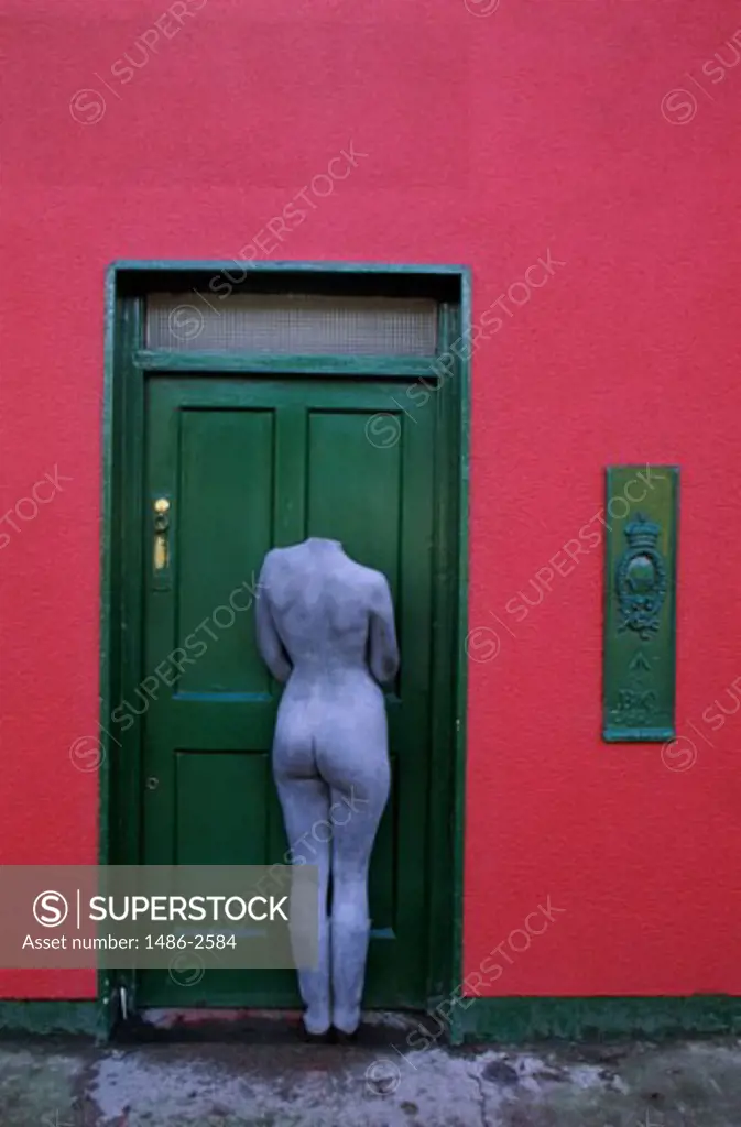 Headless statue in front of a door, Innishannon, County Cork, Ireland