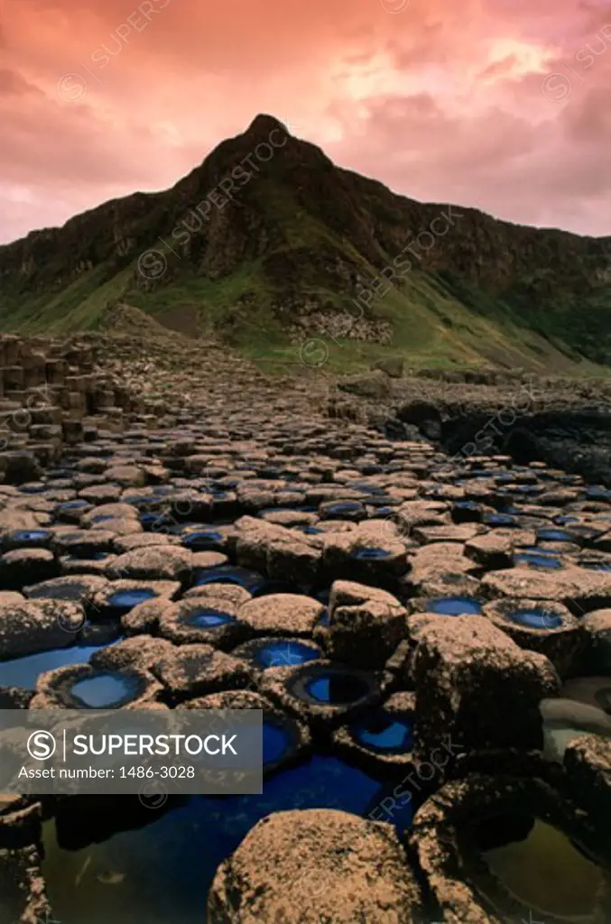 Rocks in front of a mountain, Giants Causeway, Bushmills, County Antrim, Northern Ireland