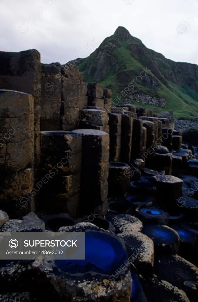 Close-up of rocks in front of a mountain, Giants Causeway, Bushmills, County Antrim, Northern Ireland