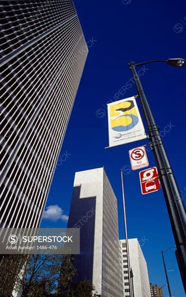 Low angle view of banners on a pole in front of buildings, Detroit, Michigan, USA