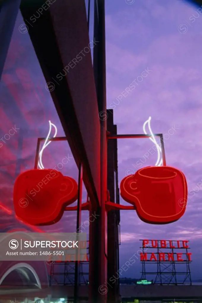 Low angle view of a coffee cup neon sign lit up at dusk, Pike Place Market, Seattle, Washington, USA
