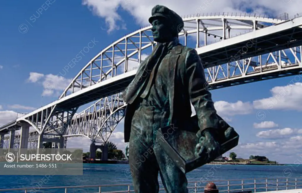 Thomas Alva Edison's statue in front of a bridge, Blue Water Bridge, St. Clair River, Port Huron, Michigan, USA