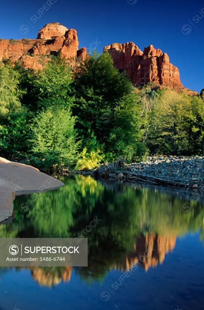 Reflection of rocks with trees in water, Cathedral Rocks, Arizona, USA