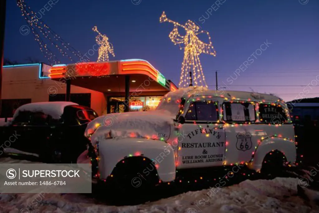 Cars in front of a building lit up at night, Williams, Arizona, USA