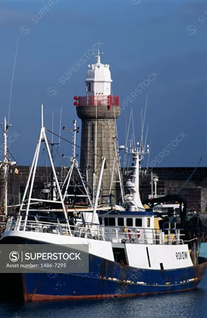 Ship docked with a lighthouse in the background, Dunmore East Lighthouse, Dunmore East, County Waterford, Republic of Ireland