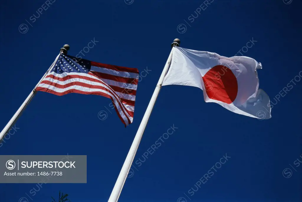Low angle view of a Japanese and American flag fluttering side by side
