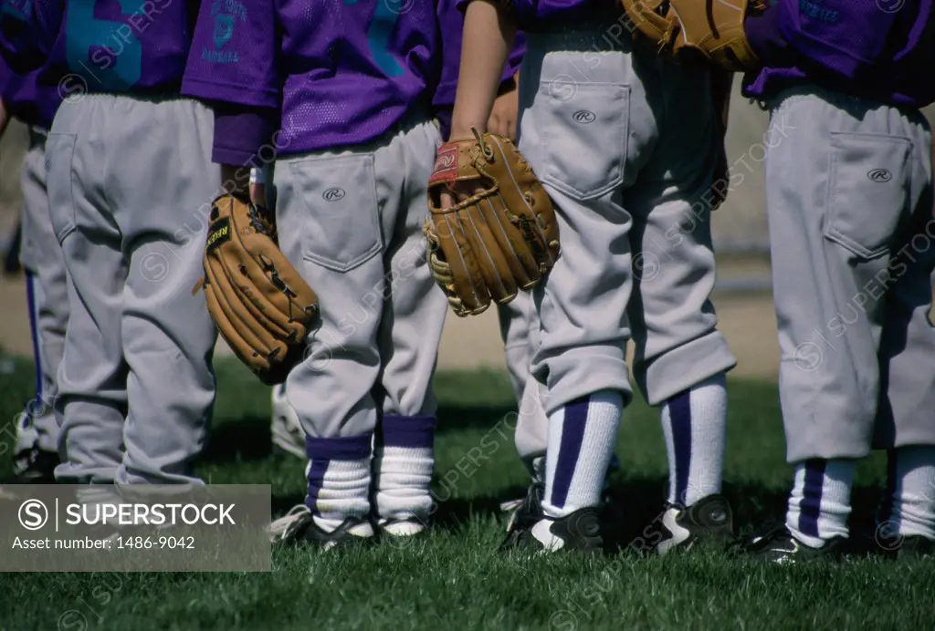 Rear view of a youth league baseball team standing in a row
