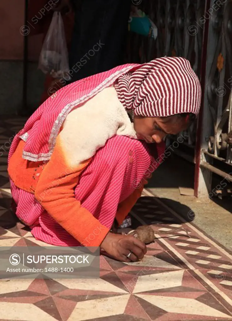 India, Rajahstan, Bikaner, Karni Mata Temple (Rat Temple), Girl feeding rat