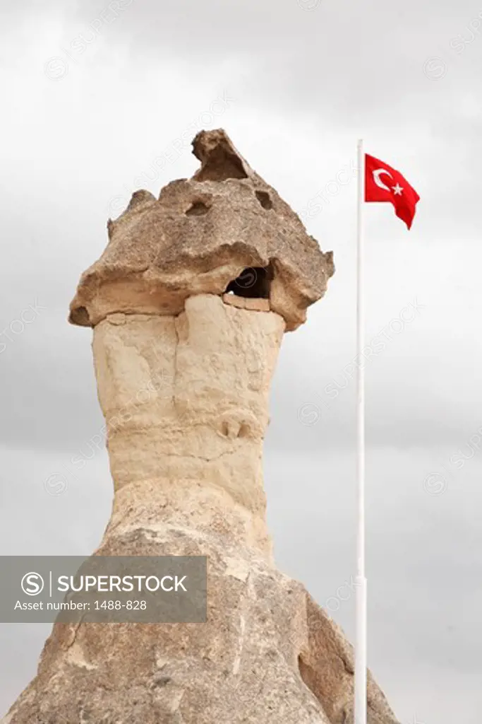 Turkish flag next to a volcanic tufa, Uchisar, Cappadocia, Central Anatolia, Turkey