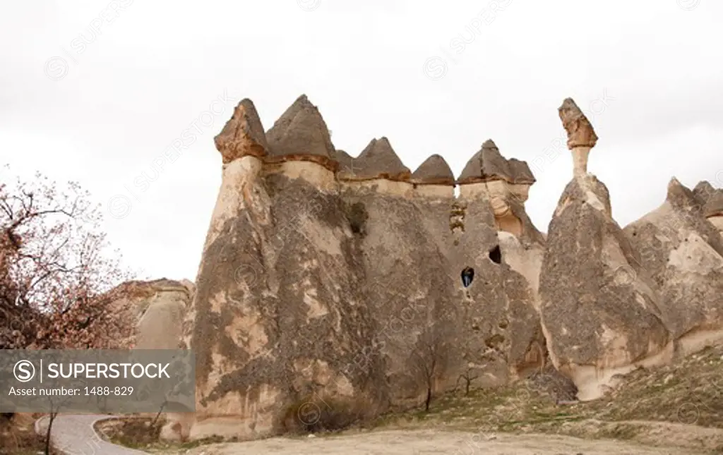 Volcanic Tufas With ancient Cave Houses and peach trees, Cappadocia, Central Anatolia, Turkey