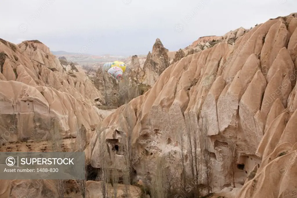 Distant hot air balloons About to Take Off in the scenic area of Volcanic Tufas and ancient Cave Houses, Cappadocia, Central Anatolia, Turkey