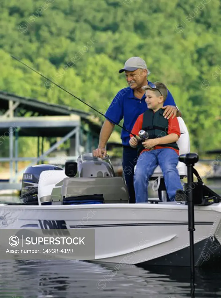 Grandfather and his grandson fishing on a boat