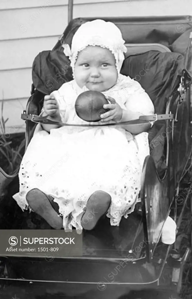 Baby girl sitting in a strollec.1913