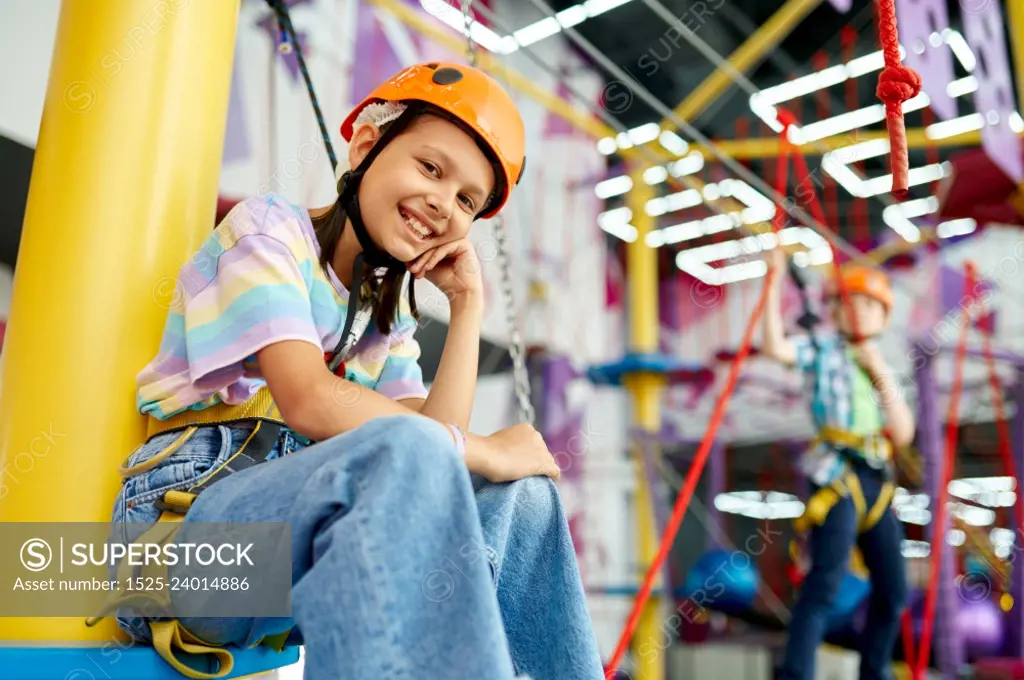 Happy girl in climbing area, kids spend the weekend on playground, active childhood. Happy girl in climbing area