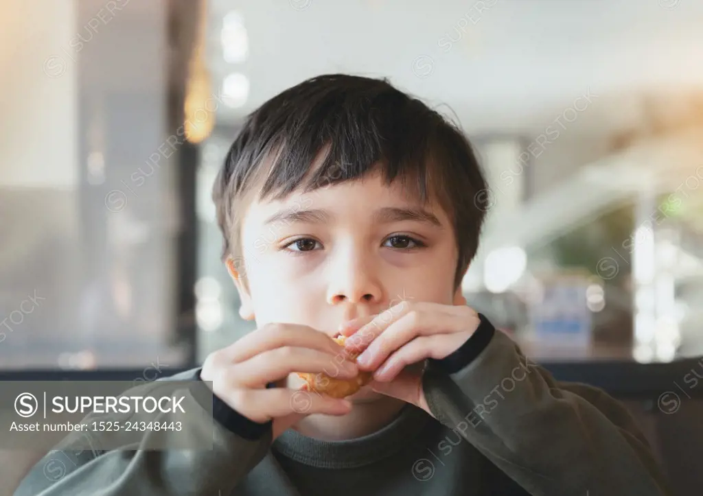 Portrait Kid bitting hash brown for breakfast, Healthy Child boy eating English Breakfast in the cafe or restaurant, Healthy food concept