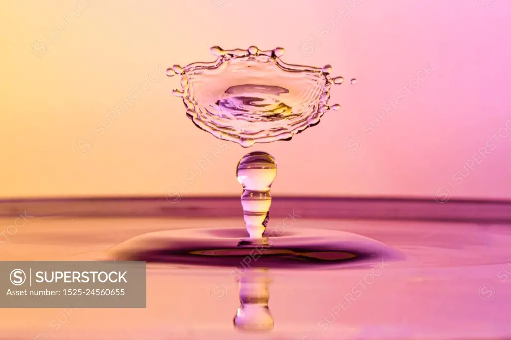 High speed water drop photograph with colliding drops in orange and purple colors. High speed water drop photograph with colliding drops