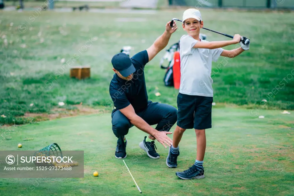 Golf Lesson. Golf Instructor Teaching Young Boy How to Swing 